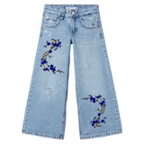 Pruimen Bloesem Tak Strijk Embleem Patch Kobalt Blauw twee maal op de broekspijpen van een spijkerbroek