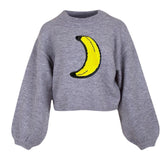 Banaan Reversible Paillette Strijk Embleem Patch op een grijze sweater