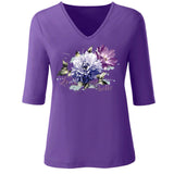 Bloem opstrijk applicatie met tekst La Vie Est Belle op een paars t-shirt met v-hals
