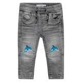 twee maal de Cartoon dolfijn strijkpatch geborduurd voor kinderkleding en accessoires op een kleine grijze spijkerbroek