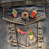 Cactus Emaille Pin In Pot samen met drie andere emaille pins.