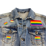 Close up van meerdere regenboog kleuren pins en een regenboog strijk patch