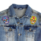 Sugar Skull Strijk Embleem Patch Geel samen met een paarse variant op een blauw spijkerjasje