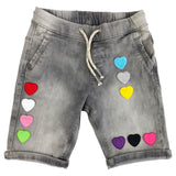 Hartje Strijk Embleem Patch Applicatie Zwart Medium samen met negen andere kleuren van deze strijk patch op een grijze korte spijkerbroek