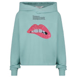 Mond Bijt Op Lip Pailletten Strijk Embleem Patch Licht Roze op een groen blauwe sweater